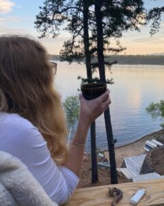 women drinking coffee on lake